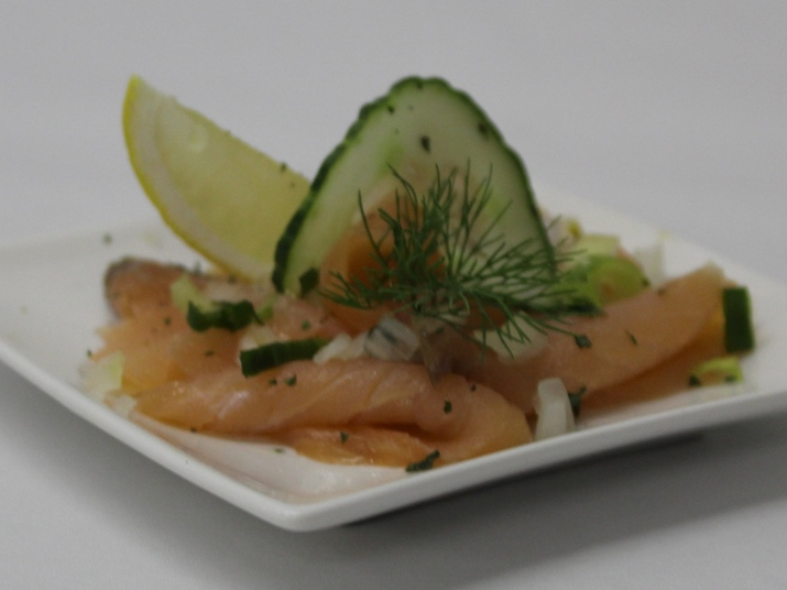 Bord carpaccio van gerookte zalm en aangepaste garnituur