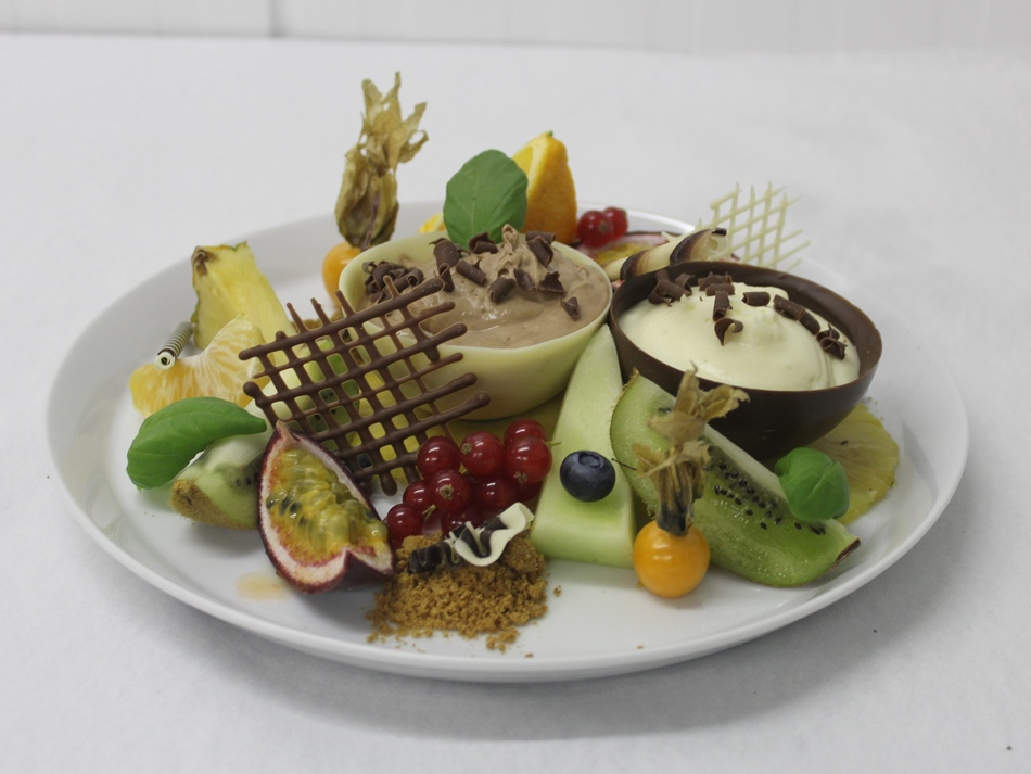 Duo van witte en bruine chocolademousse op een bordje met vers fruit