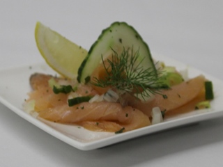 Bord carpaccio van gerookte zalm en aangepaste garnituur